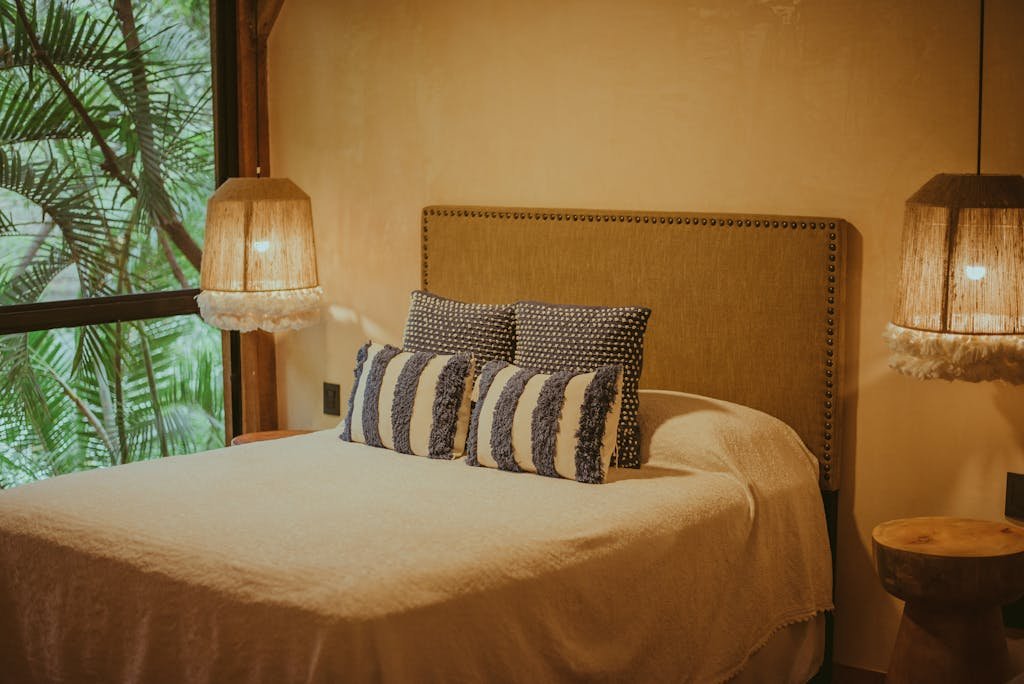 A luxurious tropical-themed bedroom featuring rustic lighting and lush palm view for ultimate relaxation.