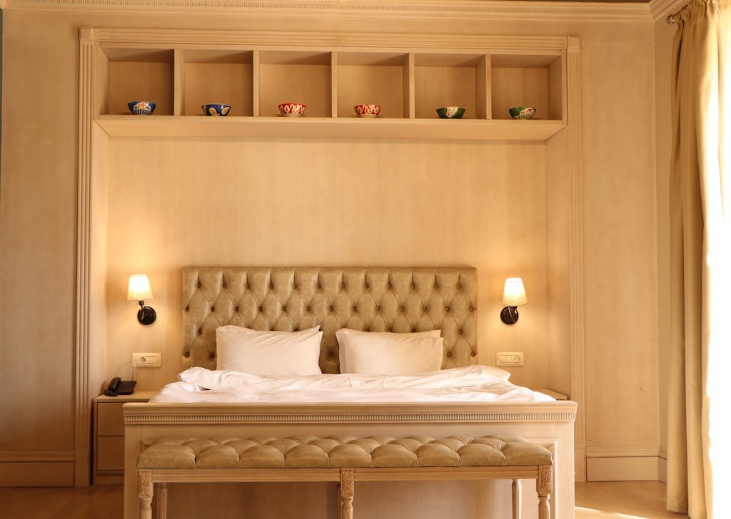 Chic beige hotel room in Baku featuring a plush tufted headboard and elegant interior design.